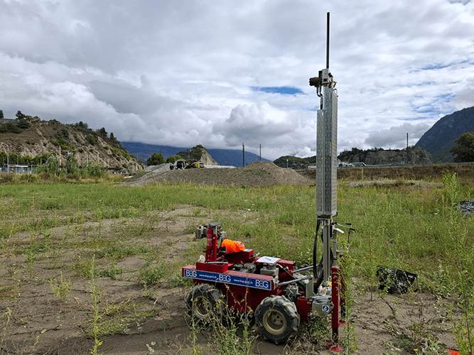 Une machine de mesure rouge de BEG installée dans un terrain vague.
