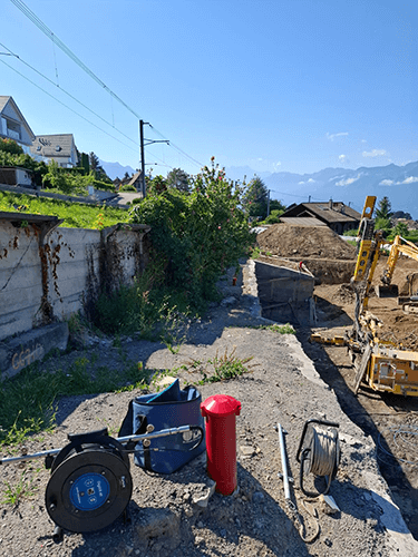 Des instruments de mesure du Bureau BEG déposés en bordure de travaux le long d'une ligne de train.